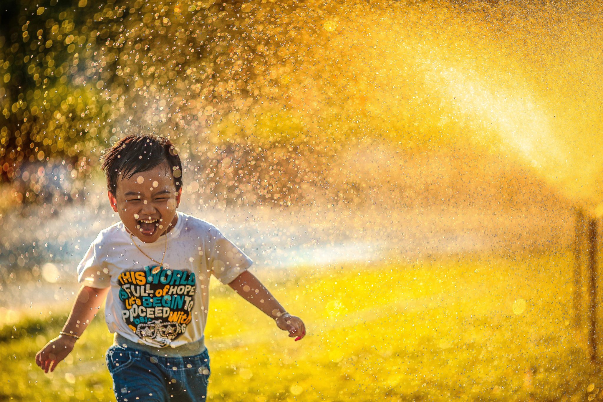 Boy playing with water from garden hose